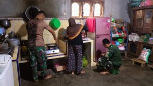 Anggota Satgas TMMD 121 Bantu Ibu Asuh Memasak di Dapur