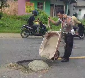 Bahayakan Pengguna Jalan, Polisi Tambal Jalan Berlubang di Pringsewu